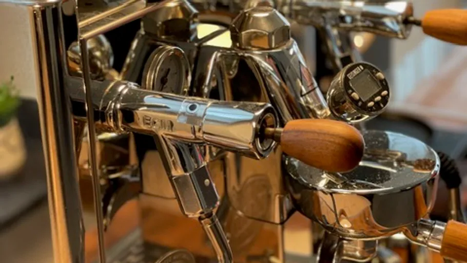 Shiny espresso machine with wooden handles.