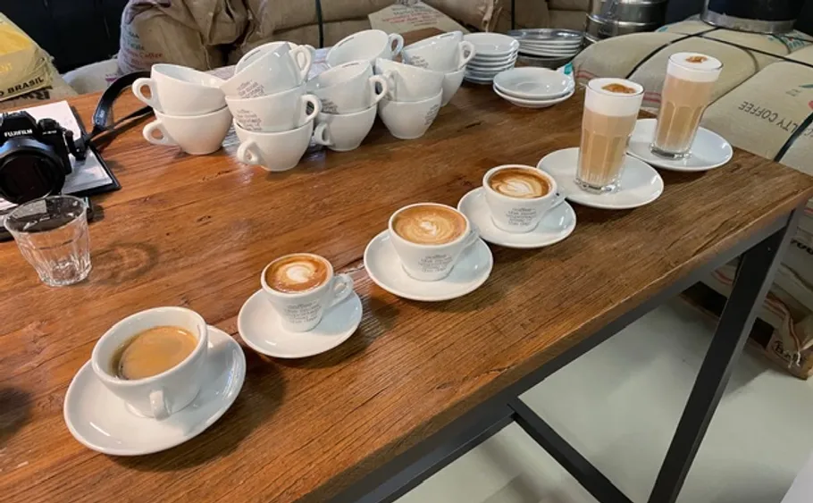 Verschiedene Kaffeestile auf Holztisch.