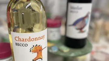 Two wine bottles with bird labels on a table.