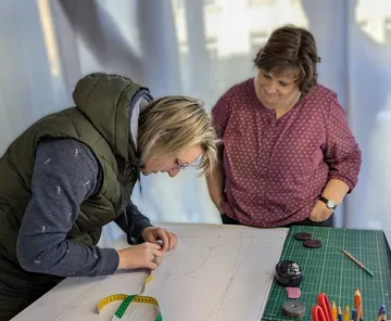 Zwei Personen arbeiten an einem Designprojekt.