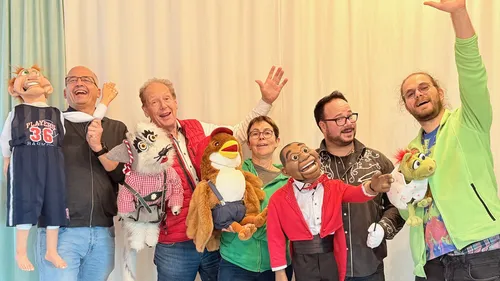 People holding puppets, smiling indoors.