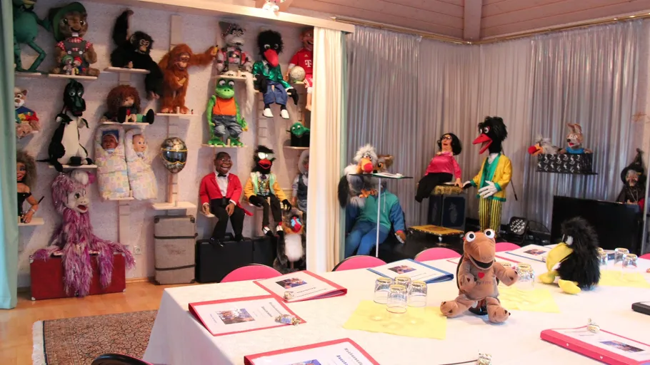 Room with puppets on display and table setup.