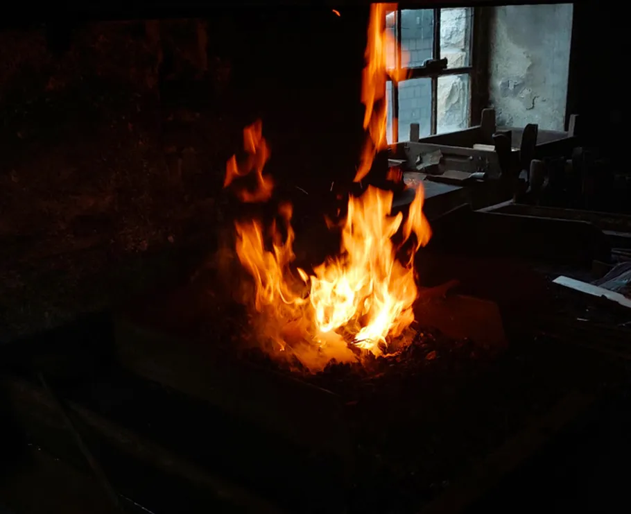 Flames rising in a dark workshop.