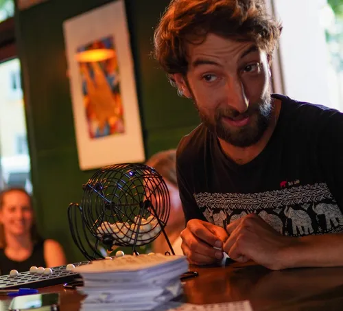Man in t-shirt playing bingo in bar.
