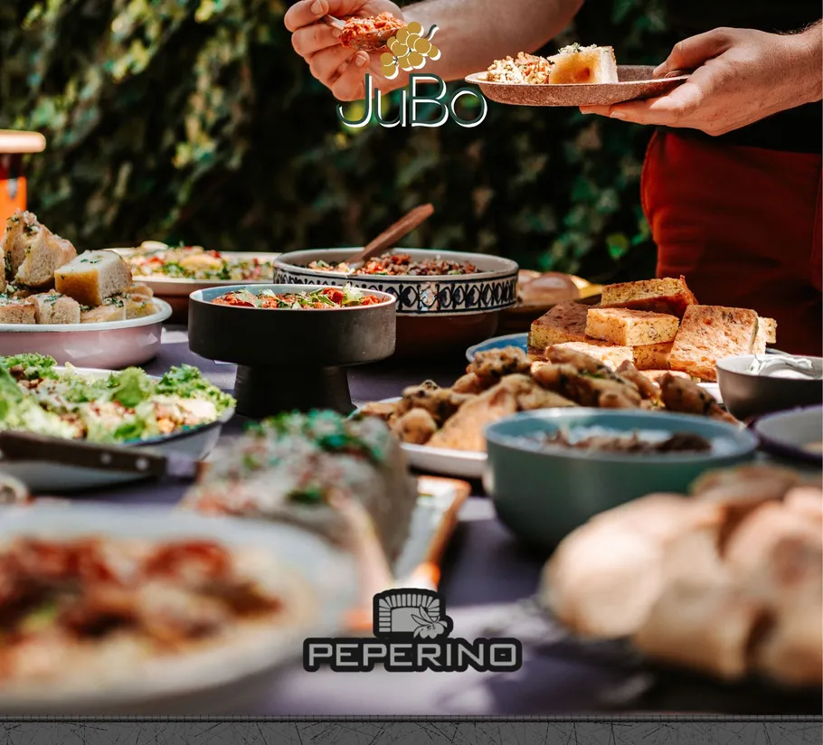 Person serviert Essen an einem Tisch im Freien.