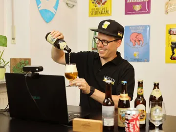 Bier wird in ein Glas in einem gemütlichen Raum gegossen.
