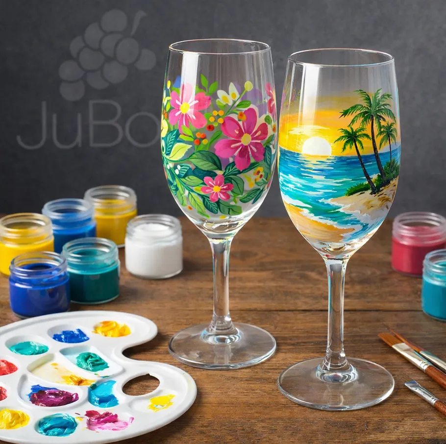 Painted wine glasses with colorful designs on table.