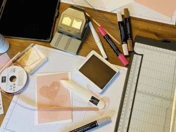 Writing utensils and craft materials scattered on a table.