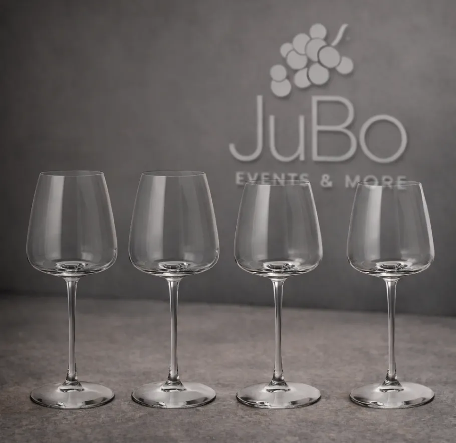 Four empty wine glasses on gray surface.