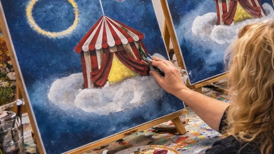 Artist painting circus tent on canvas.