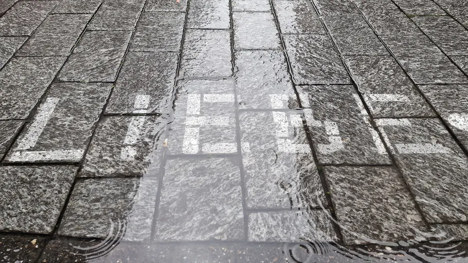 Pavement with "Liebe" reflected in water.