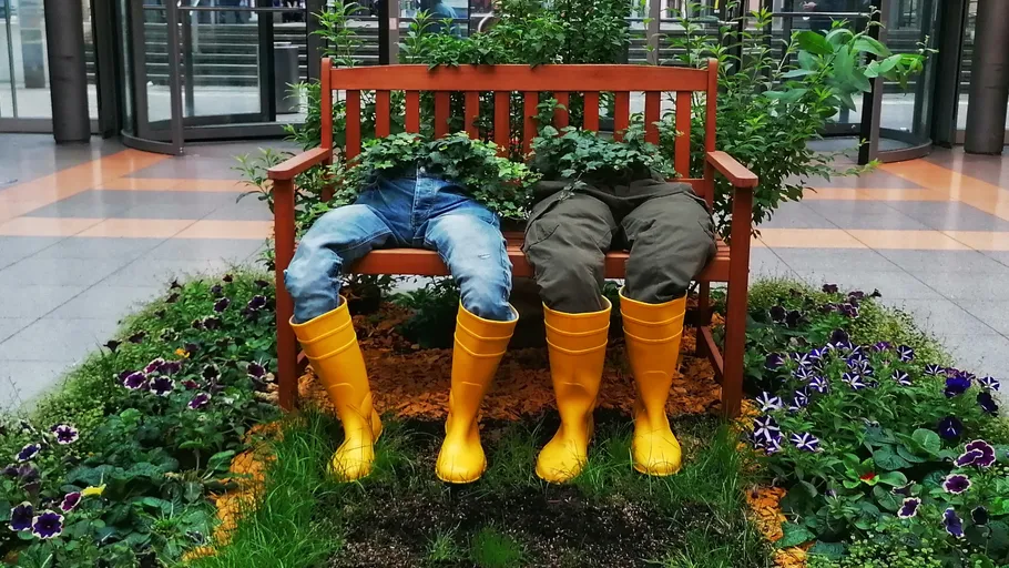 Zwei Pflanzer mit Beinen auf Bank drinnen.