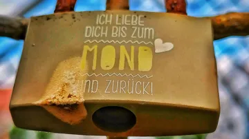 Rostiges Vorhängeschloss mit romantischer Gravur.
