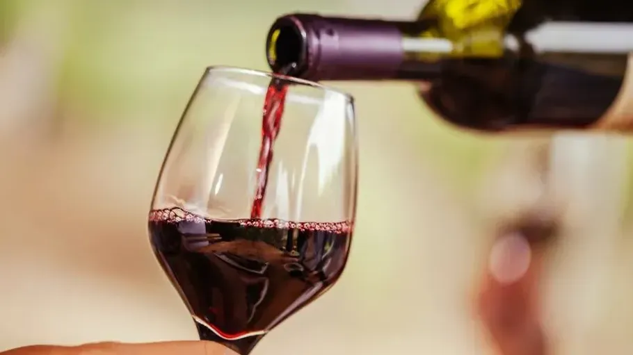 Rotwein wird in ein Glas gegossen.