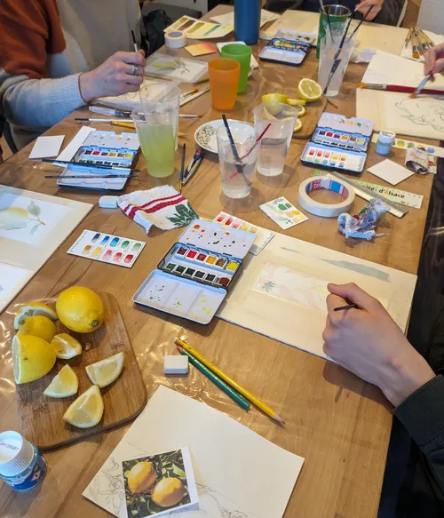 People painting with watercolors at a table.