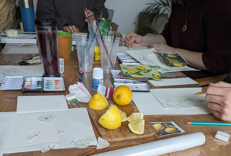People drawing lemons on a table.