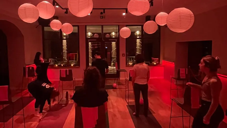 People doing yoga in dimly lit studio.
