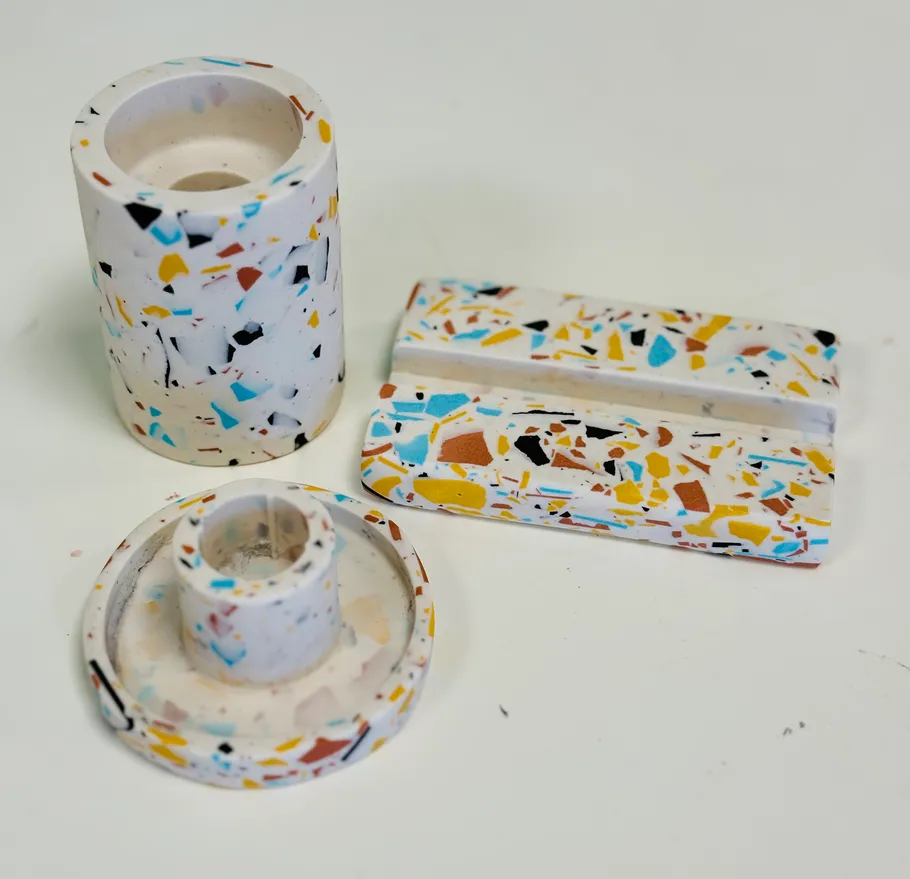 Bunte Terrazzo-Gegenstände auf weißer Oberfläche.