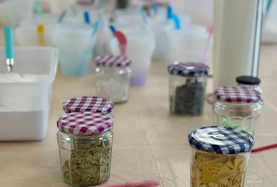Jars with colorful lids on a table.