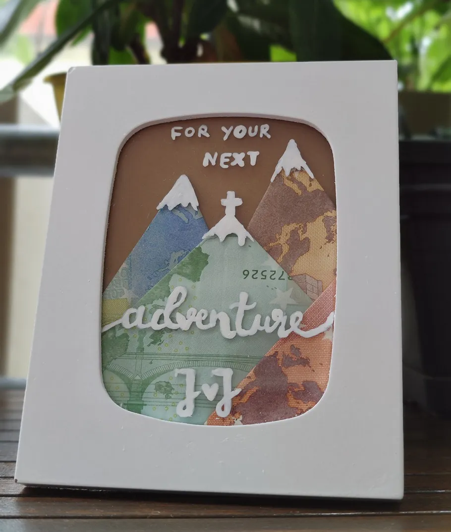 Card with mountains and text, indoor background.