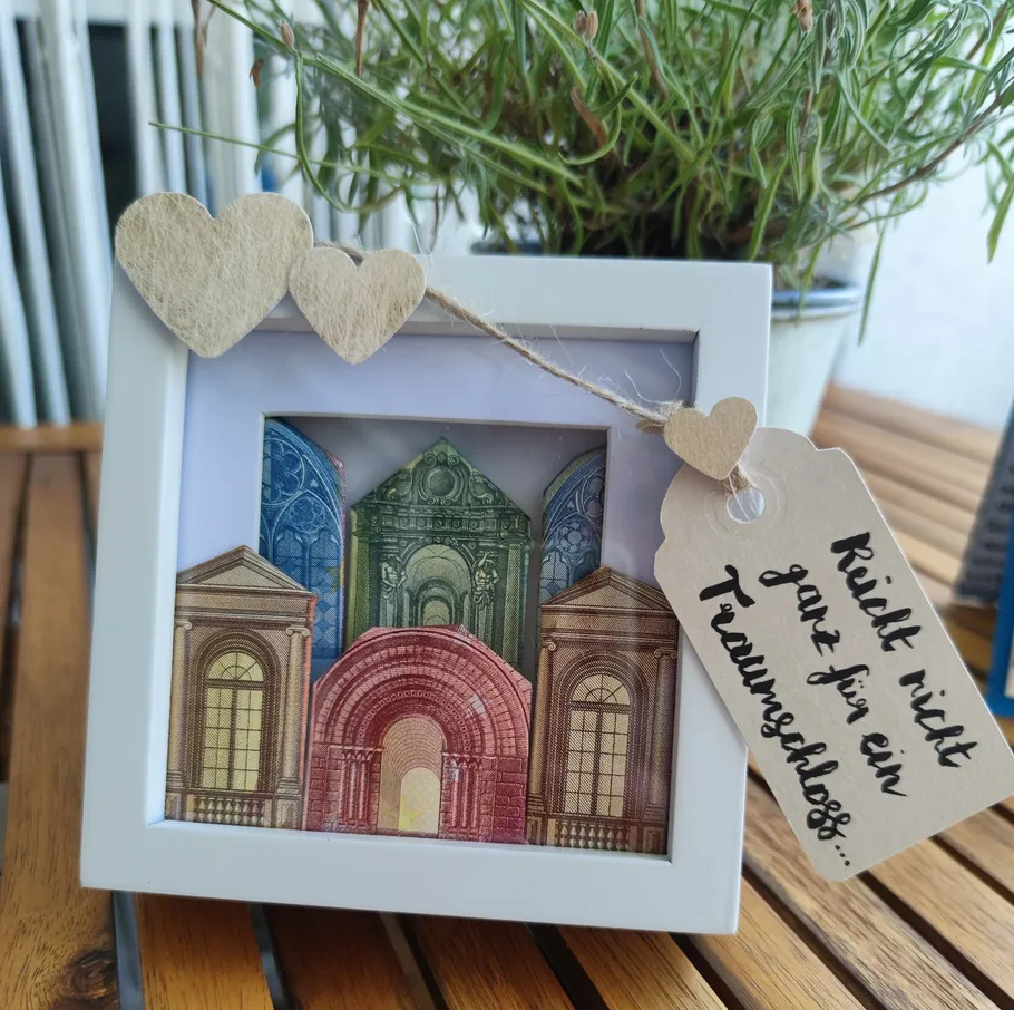 Framed banknote art with three paper hearts.