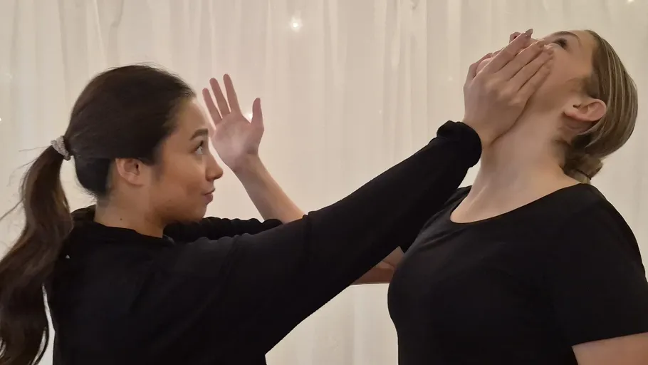 Zwei Frauen interagieren spielerisch drinnen.