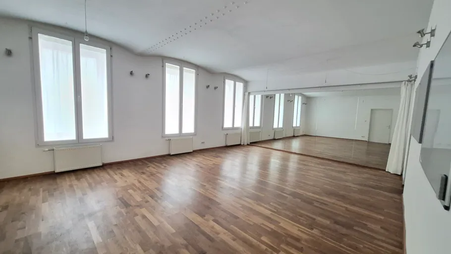 Empty dance studio with wooden floor.