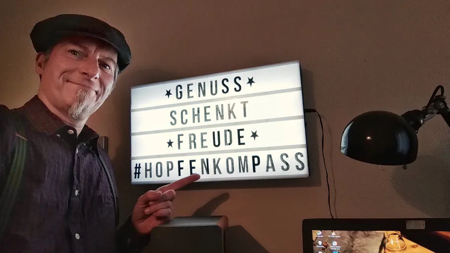 Mann zeigt auf Leuchtkasten mit deutschem Text.