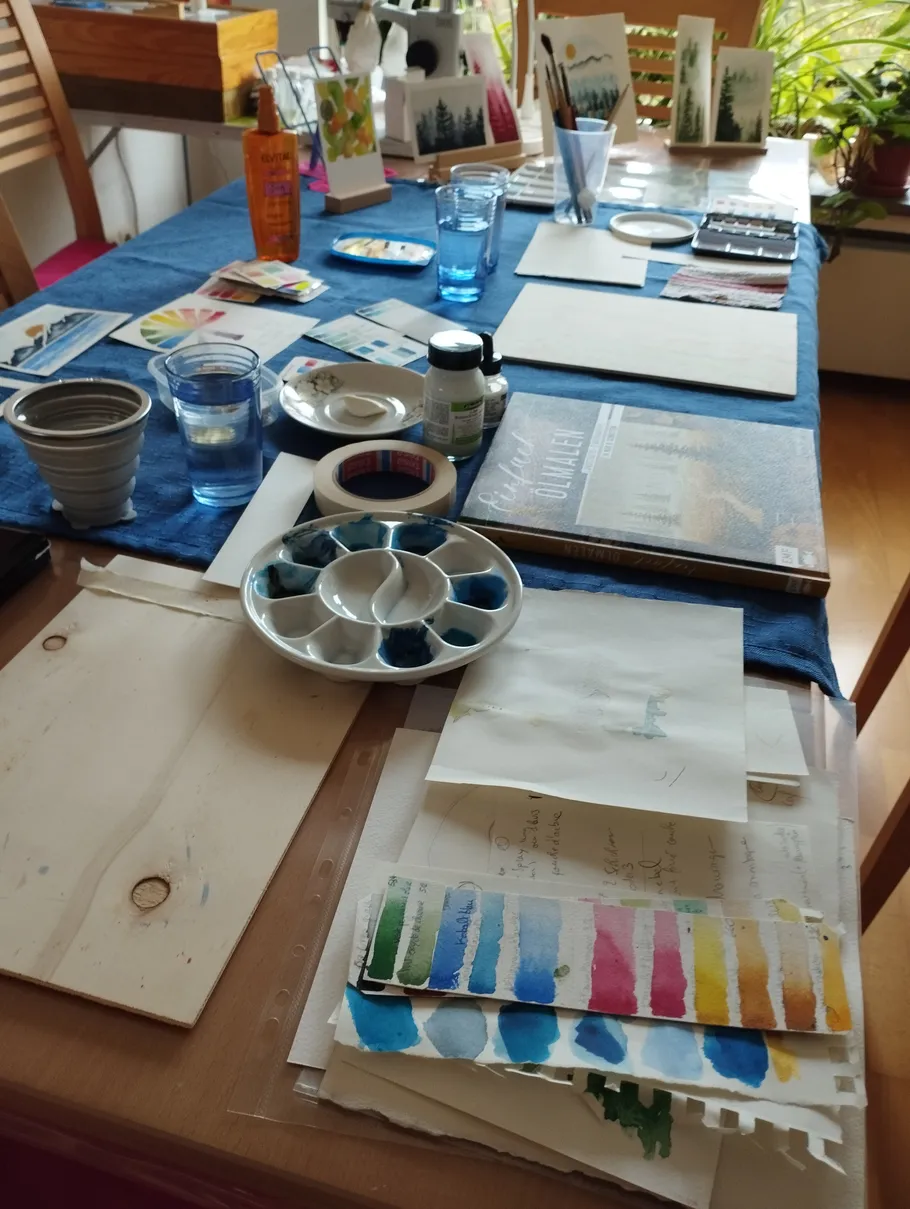 Kunstmaterialien auf einem Tisch angeordnet.