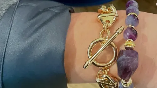 Goldarmband und Perlenarmband am Handgelenk.