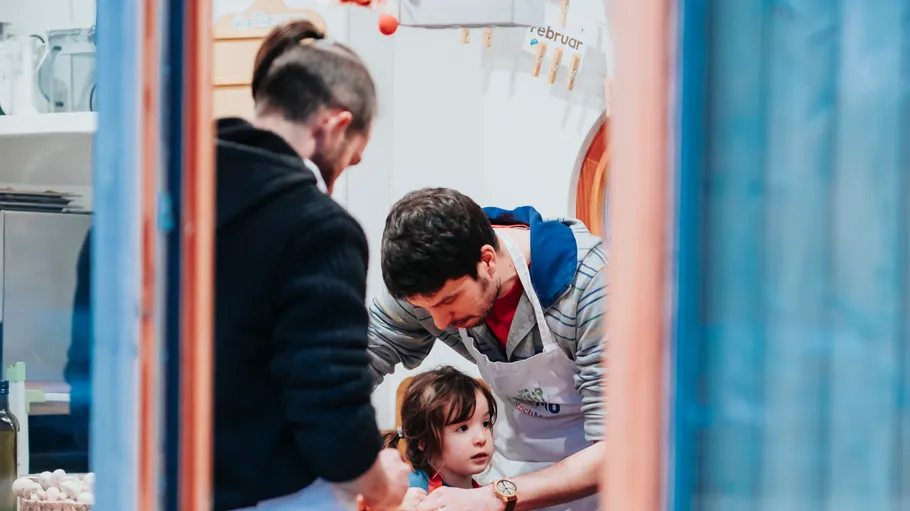 Three people cooking together indoors.
