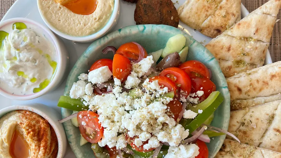 Mediterranean platter with salad, pita, and dips.