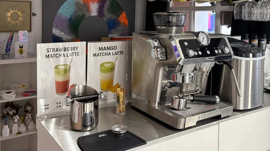 Espresso machine on counter with drink menu.