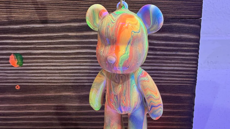 Colorful bear sculpture on wooden background.