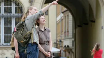 Zwei Personen, eine zeigt, in Stadtgewölbe.