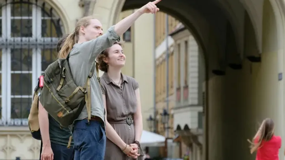 Two people, one pointing, in a city archway.