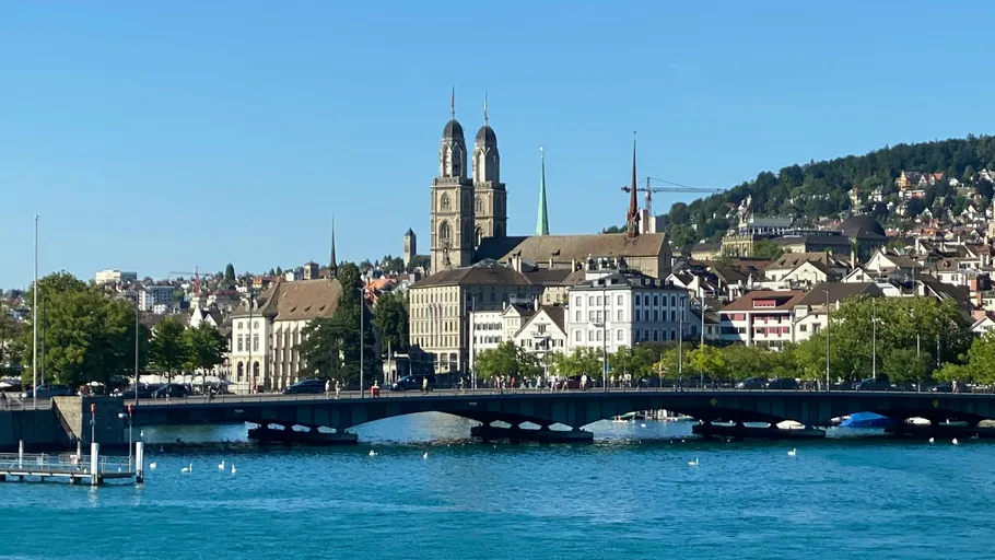 Bridge over river, city and hills in background.