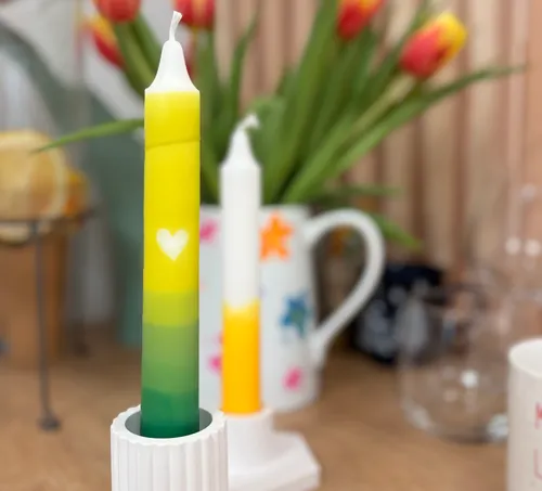 Colorful candle with heart, tulips background.