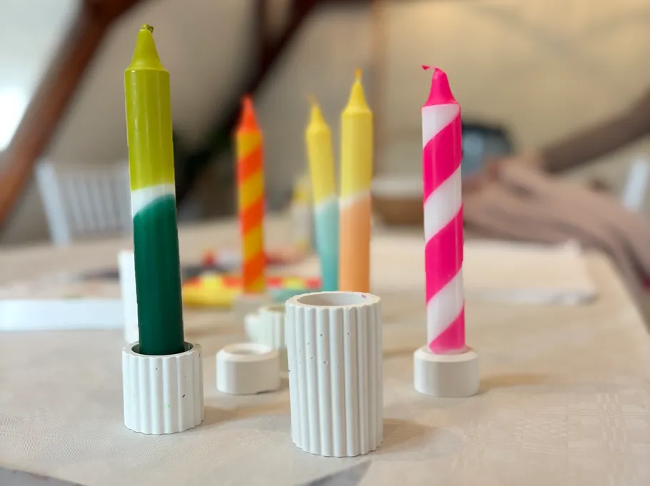 Colorful candles on a table with holders.