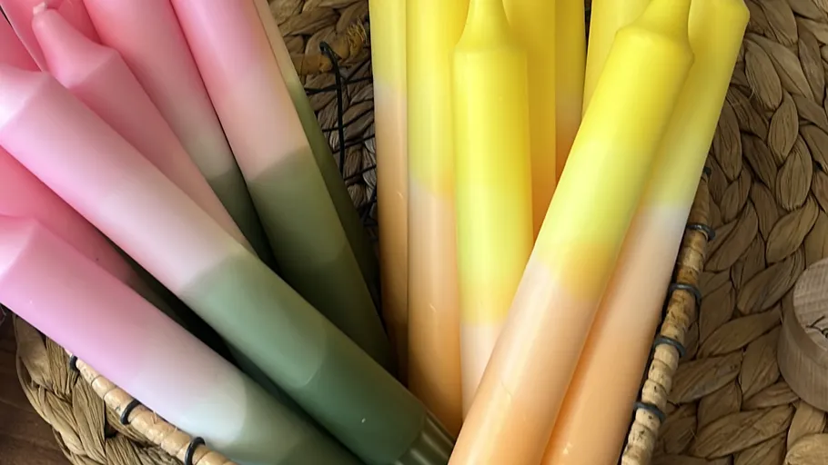 Pink and yellow gradient candles in basket.