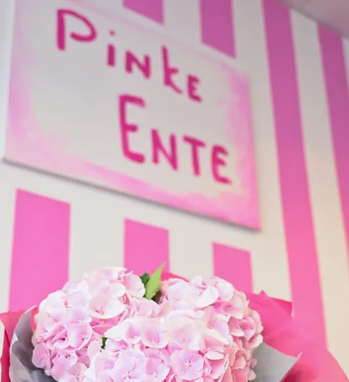 Pink flowers with striped background and sign.