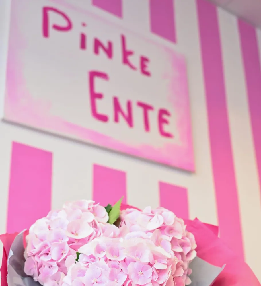Pink flowers with striped background and sign.