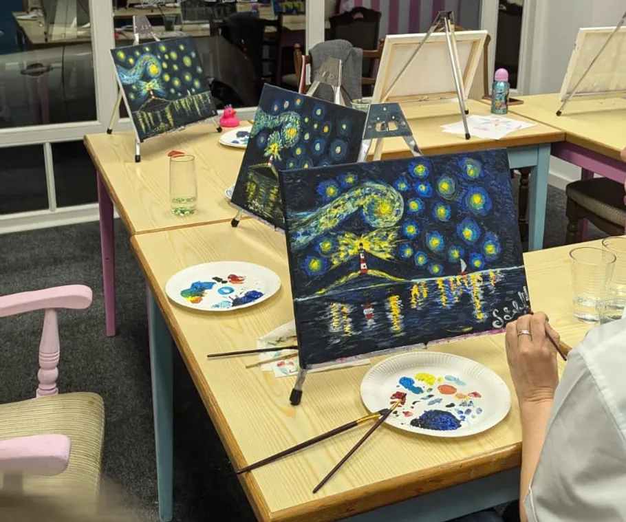 Person malt Sternennacht in Kunstkurs.