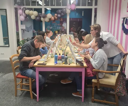 Gruppe malt im Kunstatelier mit Luftballons.