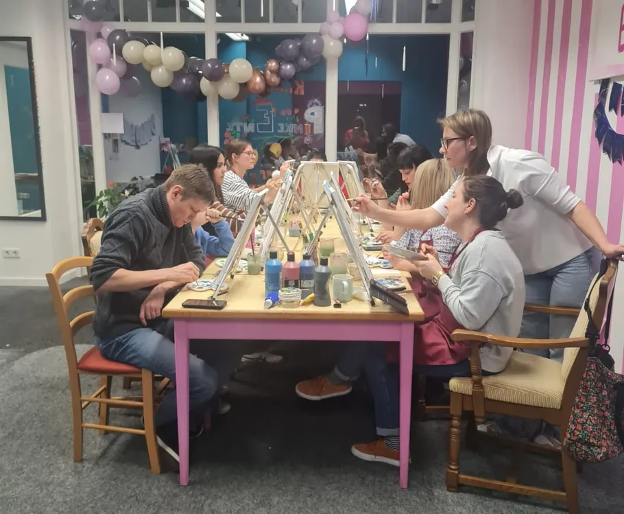 Menschen malen an einem Tisch im Studio.