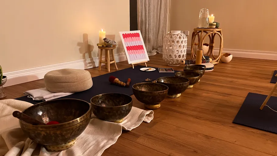 Meditationsaufstellung mit Klangschalen in gemütlichem Raum.