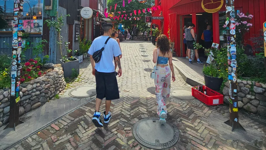 Two people walking in colorful street market.