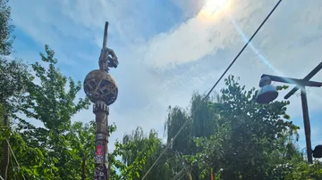 Totem pole with decorations under clear sky.