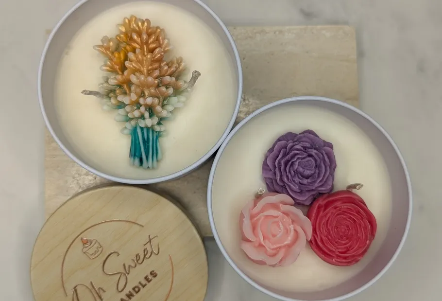 Zwei Kerzen mit detailliertem Blumendesign.