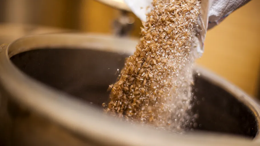 Grains being poured into metal container.